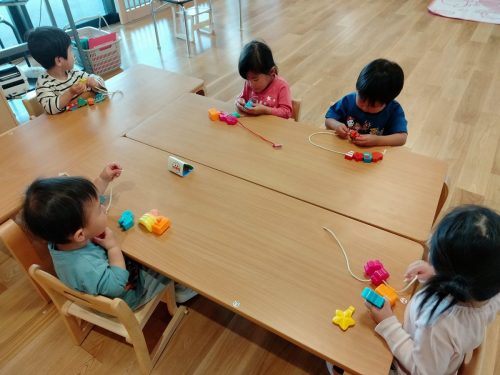 5月7日:通しやすいように紐の先を握って慎重に通しています。