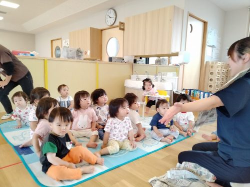 5月30日：新聞遊びをしました。先生が新聞紙で洋服を作っているのをじっと見ています。