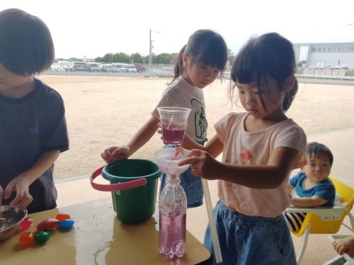 8月28日：できた色水を漏斗をつかってペットボトルに移しかえています。